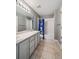 Bathroom featuring dual sinks, grey cabinets, tile flooring, and a shower with a blue patterned curtain at 5986 Dunraven Ct, Golden, CO 80403
