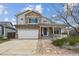 Charming two-story home featuring a stone facade, covered porch, and well-maintained front yard at 5986 Dunraven Ct, Golden, CO 80403