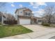 Charming two-story home showcasing stone accents, a well-manicured lawn, and an attached two-car garage at 5986 Dunraven Ct, Golden, CO 80403