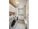 Functional laundry room equipped with modern washer and dryer, ample storage, and a convenient sink area for easy chores at 5986 Dunraven Ct, Golden, CO 80403