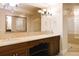Bathroom featuring a dual sink vanity, large mirror, and glass enclosed shower at 8100 E Union Ave # 2201, Denver, CO 80237