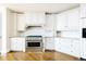 Corner view of kitchen featuring stainless steel oven range, granite countertops and custom white cabinets at 8100 E Union Ave # 2201, Denver, CO 80237
