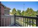 This balcony shows brick detailing and neighborhood views with mature trees at 755 Roslyn St # 17, Denver, CO 80230