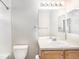 Bright bathroom featuring a single sink, large mirror, and tiled shower and bath combination at 755 Roslyn St # 17, Denver, CO 80230