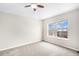 Large bedroom with neutral carpet, ceiling fan and expansive window overlooking the outdoors at 755 Roslyn St # 17, Denver, CO 80230