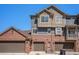Exterior showcases a multi-level townhome with a brick garage, siding, and a well-maintained facade at 755 Roslyn St # 17, Denver, CO 80230