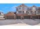 Exterior view of townhome garages with ample parking space on a sunny day at 755 Roslyn St # 17, Denver, CO 80230
