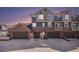 View of townhome garages with ample parking space and sunset hues in the sky at 755 Roslyn St # 17, Denver, CO 80230
