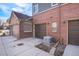 Multi-car garage, brick exterior, and an AC unit are the primary features of the building at 755 Roslyn St # 17, Denver, CO 80230