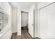 Hallway with wood floors, white walls, a large window, and multiple doors at 755 Roslyn St # 17, Denver, CO 80230