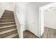 Bright hallway featuring neutral tones, carpeted stairs, and wood-look vinyl flooring at 755 Roslyn St # 17, Denver, CO 80230