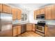 Well-lit kitchen featuring natural wood cabinets and stainless steel appliances at 755 Roslyn St # 17, Denver, CO 80230