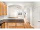 Kitchen with wood cabinets and breakfast bar opening to the naturally lit living room at 755 Roslyn St # 17, Denver, CO 80230
