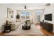 Bright living room features hardwood floors, large windows and neutral tones that create a calming atmosphere at 755 Roslyn St # 17, Denver, CO 80230