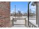 Cozy patio space with brick walls, railing, and an open view of the neighborhood at 755 Roslyn St # 17, Denver, CO 80230