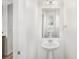 Bright powder room features a pedestal sink, a large mirror, and neutral wall color at 755 Roslyn St # 17, Denver, CO 80230
