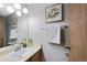 Cozy bathroom with a single sink vanity, decorative mirror and art, and a towel rack by the door at 451 Wright St # 11, Lakewood, CO 80228