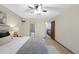 A bright bedroom features a ceiling fan, neutral walls, and access to an en-suite bathroom and staircase at 451 Wright St # 11, Lakewood, CO 80228