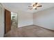 A carpeted bedroom features a ceiling fan and a closet, with a view into the hallway at 451 Wright St # 11, Lakewood, CO 80228