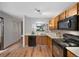 Functional kitchen with wooden cabinets, modern black appliances, and a window overlooking the living space at 451 Wright St # 11, Lakewood, CO 80228