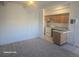 Open living space leading to a kitchen with white appliances and wood cabinets at 590 N Logan St # 303, Denver, CO 80203