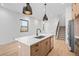 Open kitchen with wood island, stainless appliances, and modern lighting at 1250 Yates St, Denver, CO 80204