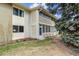 Condo exterior featuring a private sunroom, architectural accents, and partial lawn at 9320 E Center Ave # 7A, Denver, CO 80247