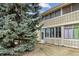 Apartment exterior showcasing a sunroom and mature trees in a grassy yard at 9320 E Center Ave # 7A, Denver, CO 80247