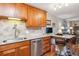 Kitchen features wood cabinets, stainless steel appliances, granite countertops, and breakfast bar with chairs at 9320 E Center Ave # 7A, Denver, CO 80247