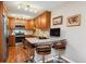 Well-lit kitchen features wood cabinets, stainless steel appliances, granite countertops, and breakfast bar with three chairs at 9320 E Center Ave # 7A, Denver, CO 80247