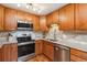 Bright kitchen featuring wood cabinets, stainless steel appliances, tile backsplash, and granite countertops at 9320 E Center Ave # 7A, Denver, CO 80247