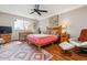 Bright bedroom with wood floors, ceiling fan, work desk, comfortable seating, and colorful area rug at 9320 E Center Ave # 7A, Denver, CO 80247