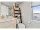 Charming bathroom with ladder shelving, updated vanity and natural light from the window at 2420 S Gilpin St, Denver, CO 80210