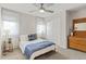 Cozy bedroom with a bed, bedside tables, and wooden dresser, illuminated by a ceiling fan at 2420 S Gilpin St, Denver, CO 80210