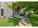 Charming front entrance with brick and wood accents, complemented by cozy seating and a well-manicured lawn at 2420 S Gilpin St, Denver, CO 80210