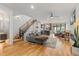 Inviting living room features hardwood floors, a staircase with black metal railing, and an open-concept design at 2420 S Gilpin St, Denver, CO 80210