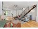 Spacious living room with hardwood floors, a cozy gray sectional, and a modern staircase with metal railing at 2420 S Gilpin St, Denver, CO 80210