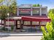 Exterior view of John Holly's Asian Bistro with a red awning and sidewalk seating at 2420 S Gilpin St, Denver, CO 80210