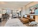 Open-concept living room and kitchen with modern decor, wood floors, and ample natural light at 9023 E Northfield Blvd, Denver, CO 80238