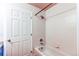 White tiled bathroom featuring a bathtub and shower, next to a white door at 13351 W Alameda Pkwy # 203, Lakewood, CO 80228