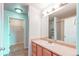 Bathroom featuring a vanity with a sink, mirror, and tile flooring, leading to a closet and shower area at 13351 W Alameda Pkwy # 203, Lakewood, CO 80228