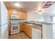 Functional kitchen with white appliances, neutral countertops, and a breakfast bar at 13351 W Alameda Pkwy # 203, Lakewood, CO 80228