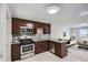 Open kitchen with stainless steel appliances, granite counters, and rich cabinetry adjoining a living area at 4812 W 8Th Ave, Denver, CO 80204