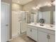 Bathroom featuring a double vanity, large shower with sliding door, and neutral tiling at 4815 Cattle Cross Rd, Castle Rock, CO 80104