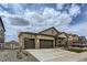 Inviting home with a three-car garage and stone-accented covered porch at 4815 Cattle Cross Rd, Castle Rock, CO 80104