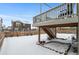 Spacious backyard deck with stairs and snow covered ground at 971 Horsetail Loop, Elizabeth, CO 80107