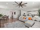 Open concept living room with kitchen view, hardwood floors, and sectional sofa at 971 Horsetail Loop, Elizabeth, CO 80107