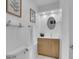 Bright bathroom with wood vanity, oval mirror, white fixtures, and decorative artwork at 6359 S Locust Way, Centennial, CO 80111
