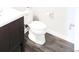 Cozy half bathroom with sink, toilet, and modern flooring at 1345 W 67Th Pl, Denver, CO 80221