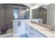 Modern bathroom featuring a glass-enclosed shower, double vanity, and sleek fixtures at 1345 W 67Th Pl, Denver, CO 80221